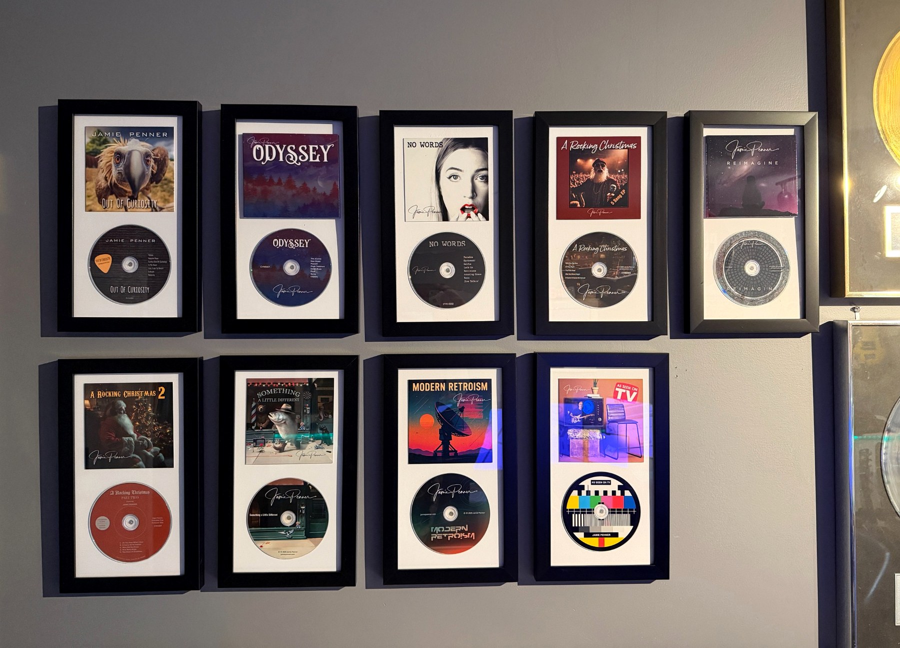 Nine framed Jamie Penner CD releases displayed on the studio wall